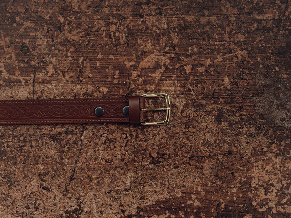 brown belt with celtic knot design and brass buckle